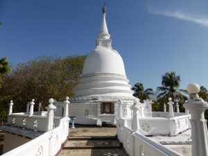 Stupa blanc du temple bouddhiste à côté de l'école